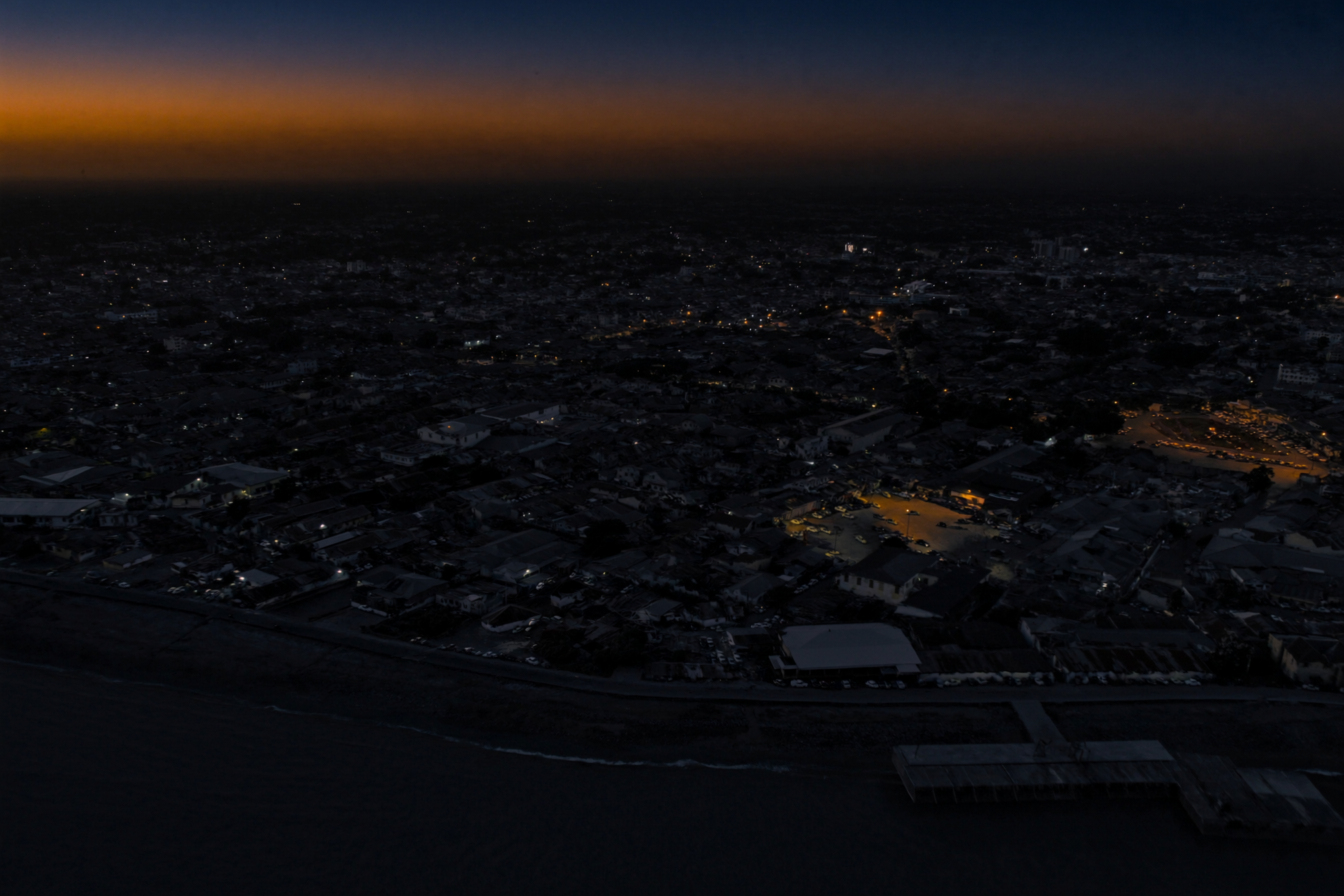 Libreville de nuit, front de mer illuminé — siège de la filiale Konnect Gabon