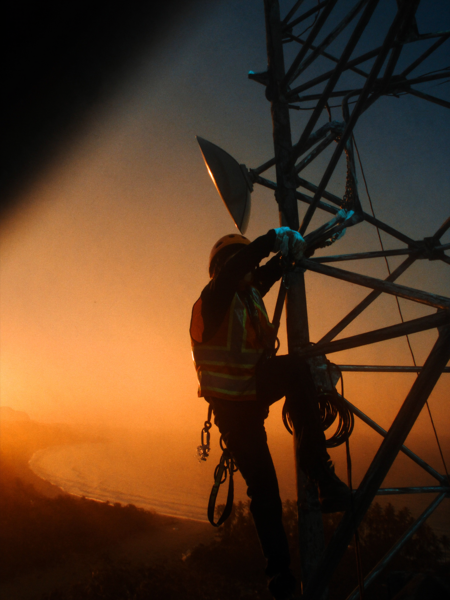 Technicien Konnect encordé sur un pylône télécom, réglage d'un faisceau hertzien